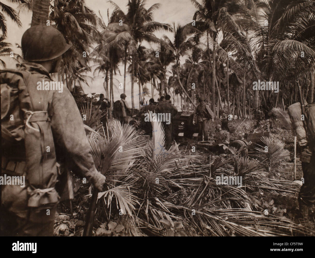 US Marine Corps WWII Pacific campaña: Los hombres sólo viene a tierra son vistos aprovechando un breve descanso antes de pasar a su Foto de stock