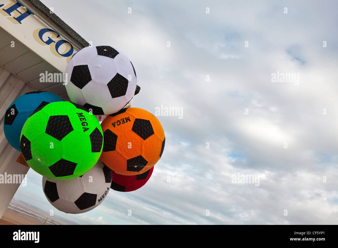 Espuma Suave balones de fútbol colgando fuera de una tienda en la playa de Weston-super-Mare en el Canal de Bristol. Foto de stock
