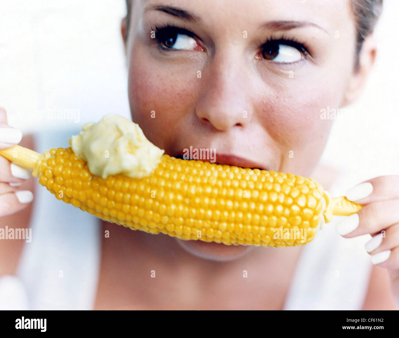 Mujeres comiendo la mazorca de maíz con mayonesa madera Fotografía