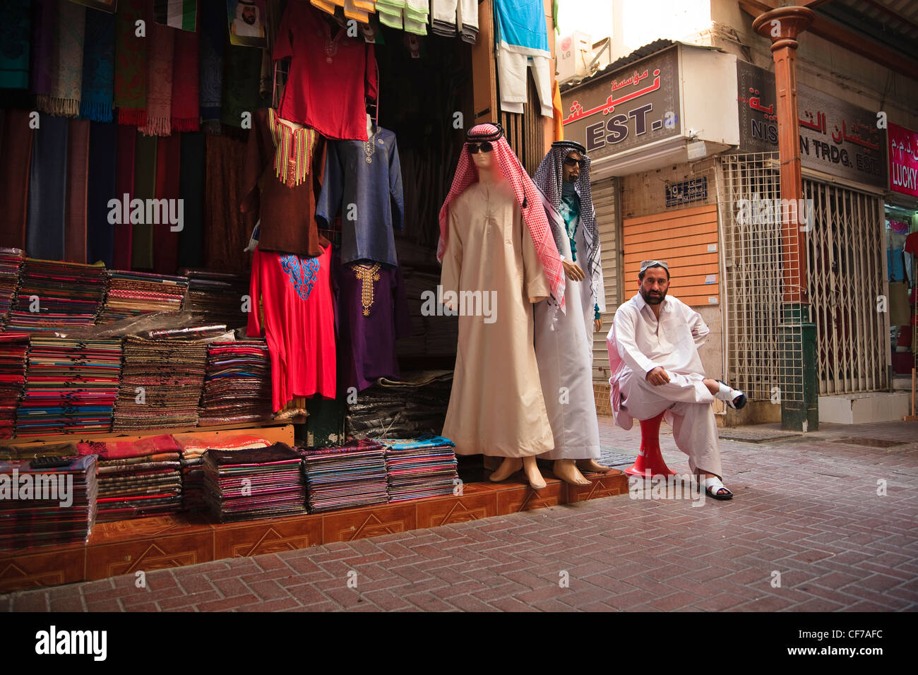 Árabe hombre sentado fuera de su tienda de ropa, Casco antiguo zoco, Dubai  Fotografía de stock - Alamy