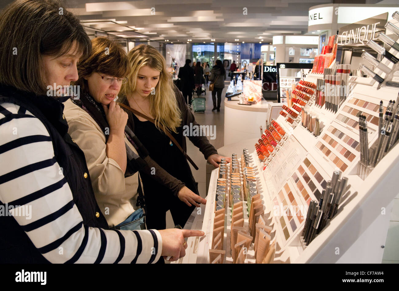 Tres mujeres caucásicas comprar cosméticos maquillaje en una tienda  departamental, REINO UNIDO Fotografía de stock - Alamy