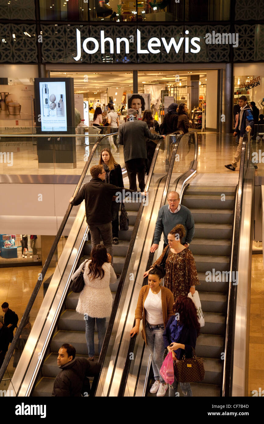 La gente subiendo las escaleras mecánicas de los almacenes John Lewis, el centro comercial Westfield, Stratford, Londres, Gran Bretaña. Foto de stock