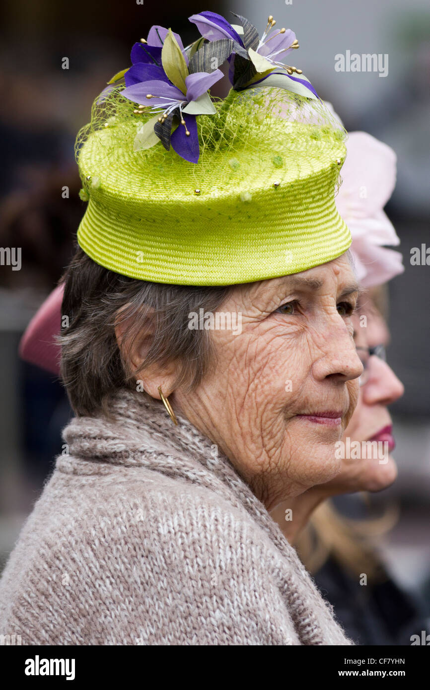 Moda mujer anciana con fancy hat viniendo desde Melbourne a las carreras de caballos fuera de la estación de Flinders Street, Melbourne, Australia Foto de stock