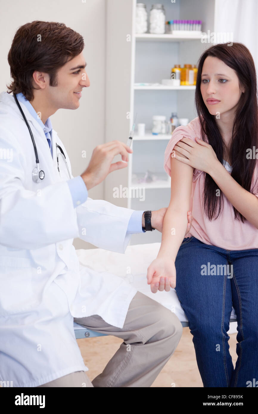 Médico varón sobre dar una inyección al paciente Foto de stock