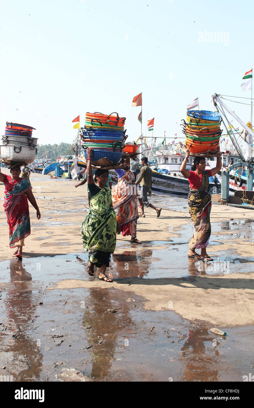 Las mujeres portadoras de trabajo indio coloridas canastas en un mercado de pescado en Malpe, Udupi, India Foto de stock