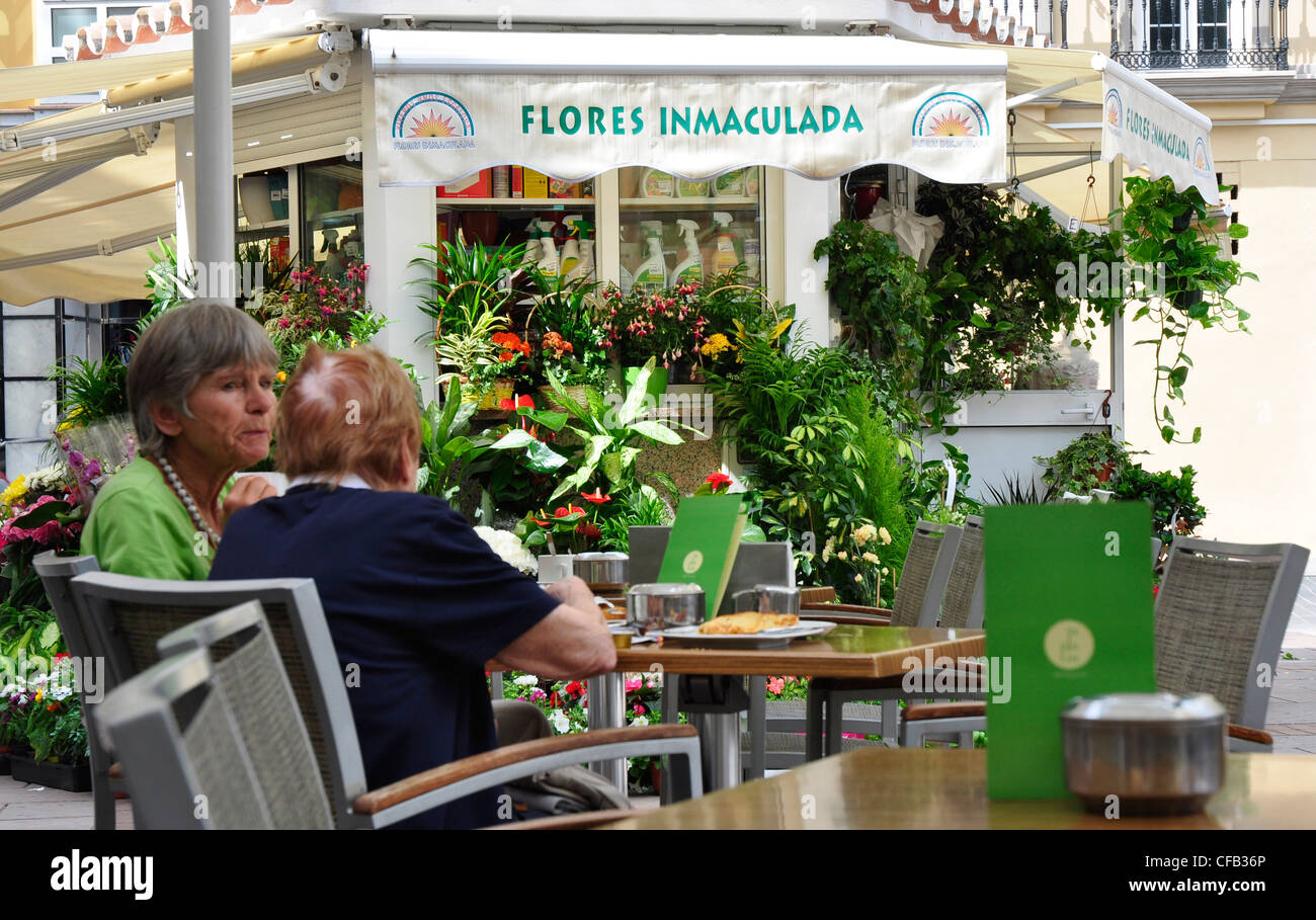 España Andulacia - Fuengirola - dos mujeres en la conversación en un cafe -  el telón de fondo de la florería Flores 