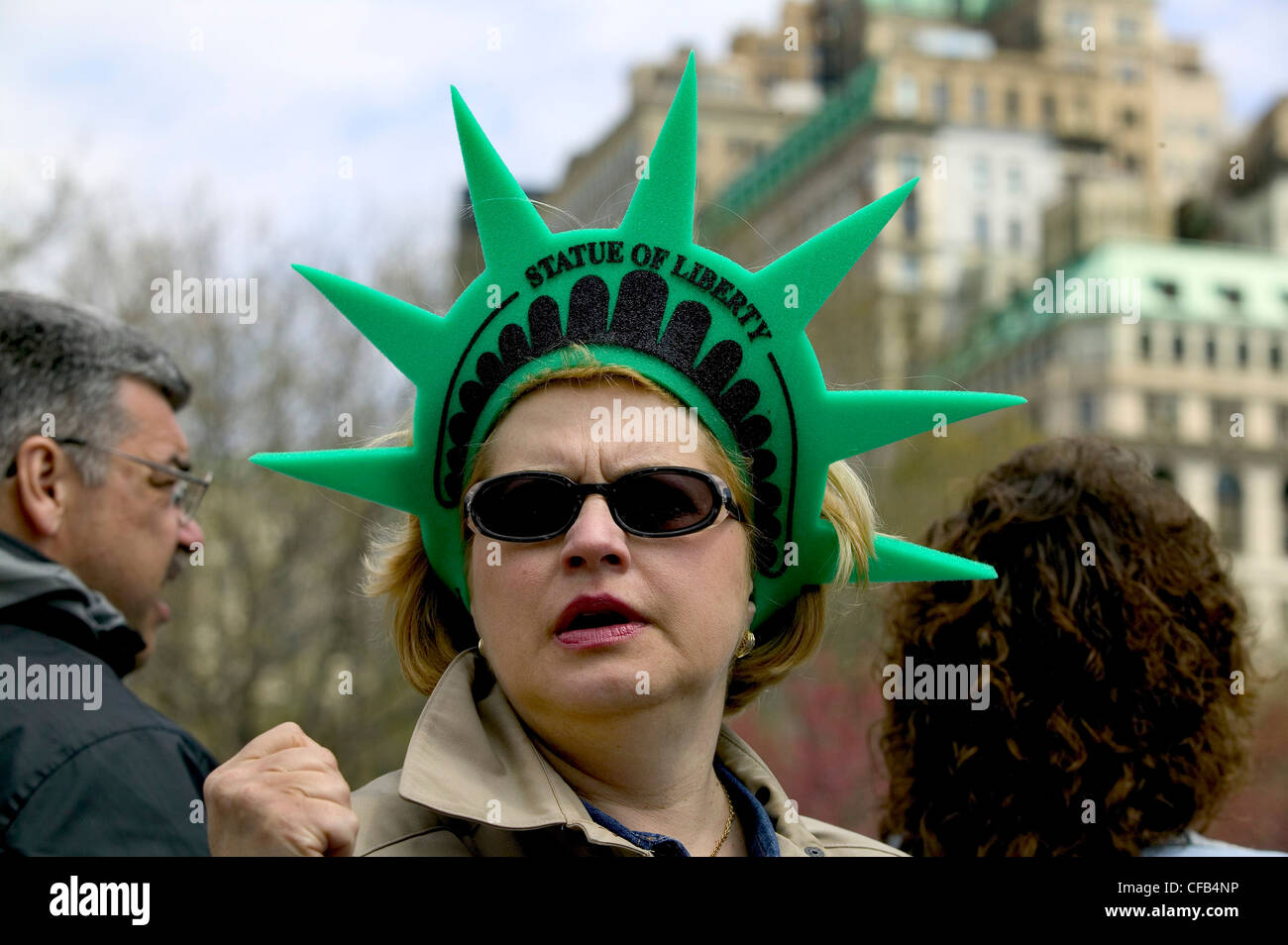 Una mujer lleva una estatua de la libertad banda de cabeza Foto de stock