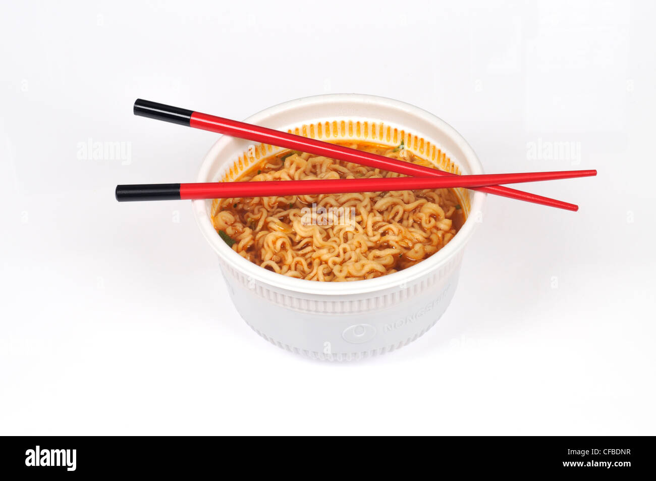 Tazón de fideos orientales con palillos sobre fondo blanco cortado Foto de stock