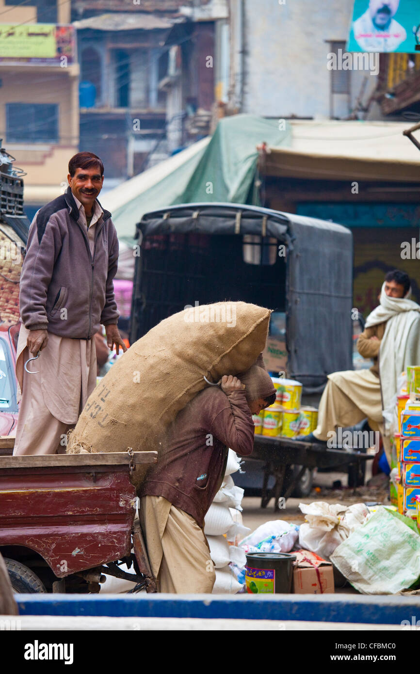 El hombre lleva producir en una tienda, Rawalpindi (Pakistán) Foto de stock