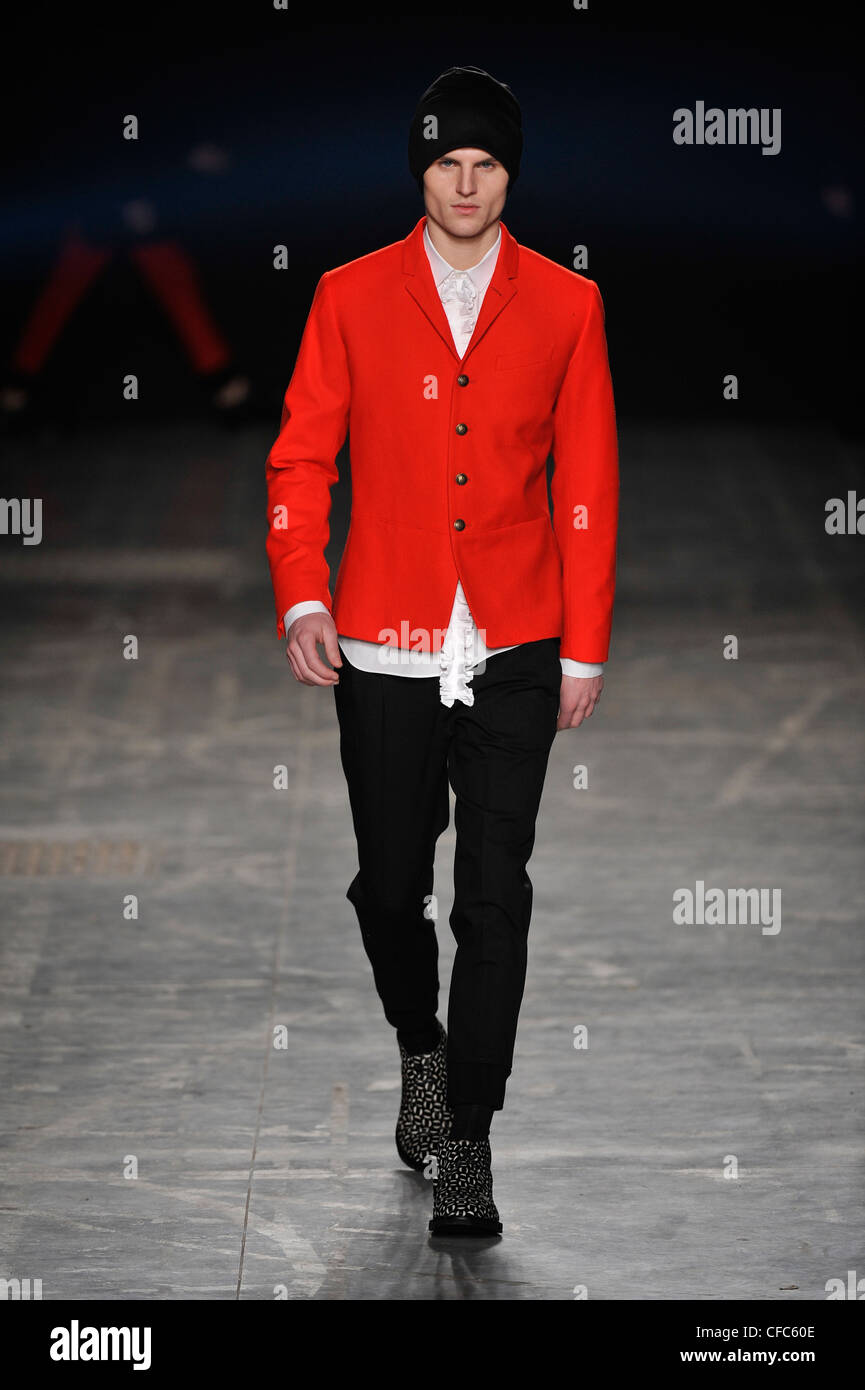 Neil Barrett Milán listo para ponerse ropa de Otoño Invierno chaqueta roja sobre camisa blanca y pantalón negro, hat Fotografía de stock - Alamy