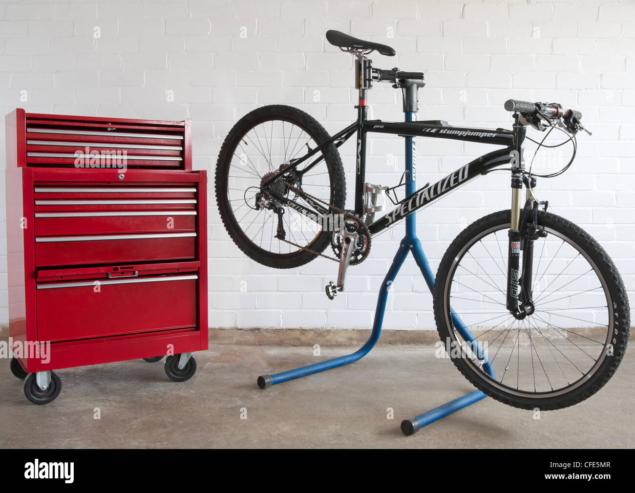 Caja de herramientas y la bicicleta de montaña en bicicleta soporte de  trabajo contra la pared de ladrillo Fotografía de stock - Alamy