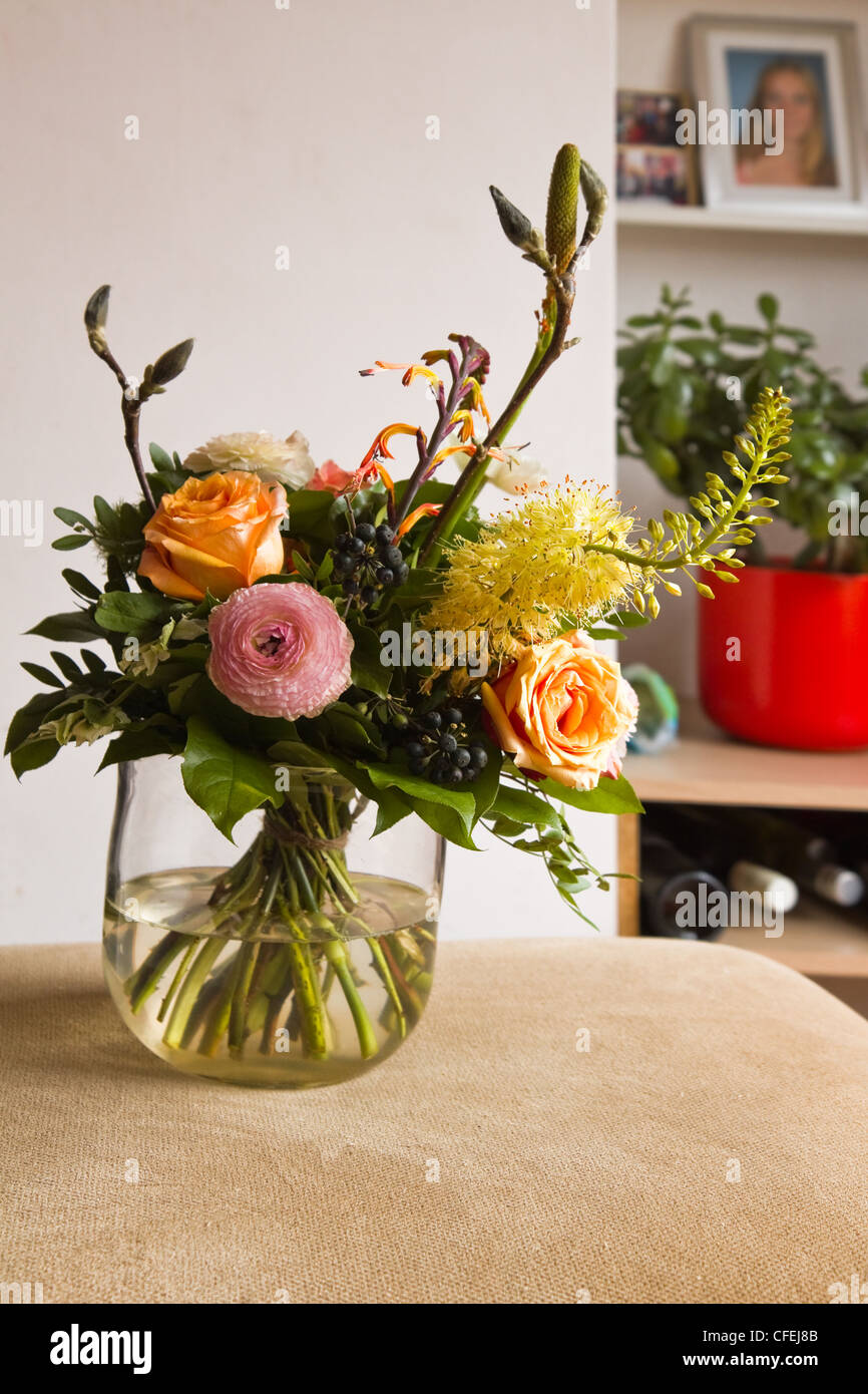Bouquet de flores con jarrón de cristal en un interior moderno Foto de stock