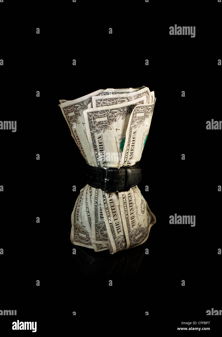 Billetes de dólar exprimido por correa simbolizando una economía apretada Foto de stock
