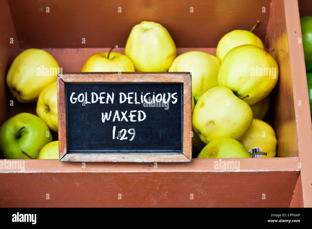 Caja de manzanas verdes maduras para la venta en un puesto en el mercado Foto de stock