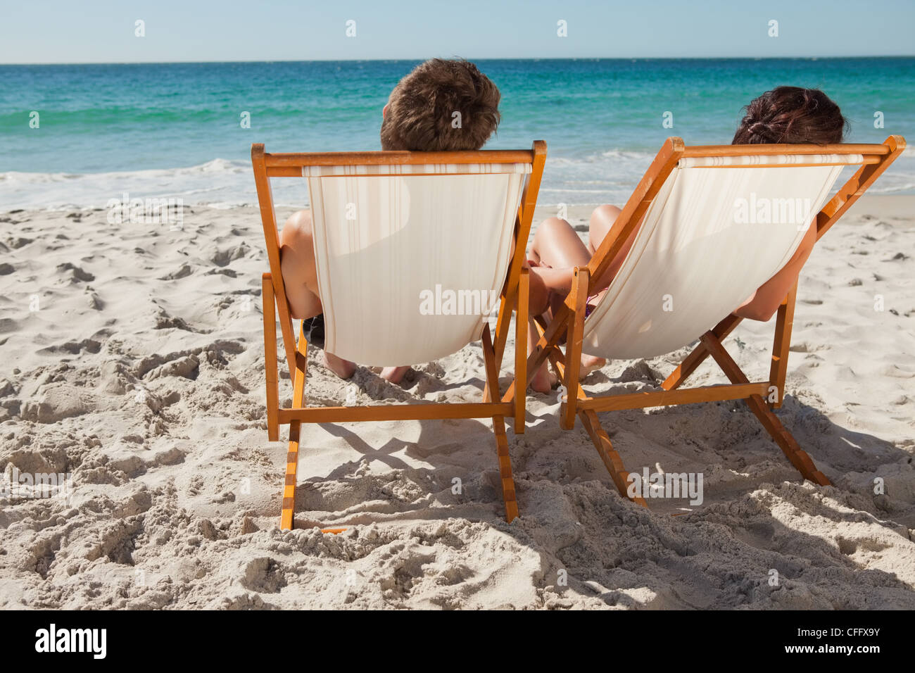 Vista trasera de la gente tomando un baño de sol en reposeras Fotografía de  stock - Alamy