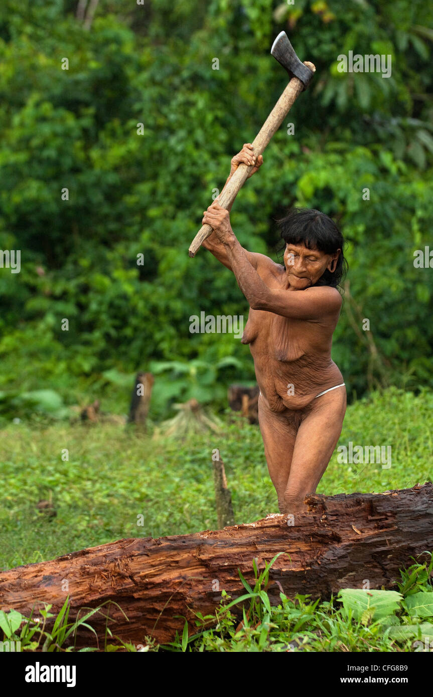 Mujer indígena huaorani picar leña para el fuego. Comunidad Gabaro, Parque Nacional Yasuní, selva Amazónica, Ecuador Foto de stock