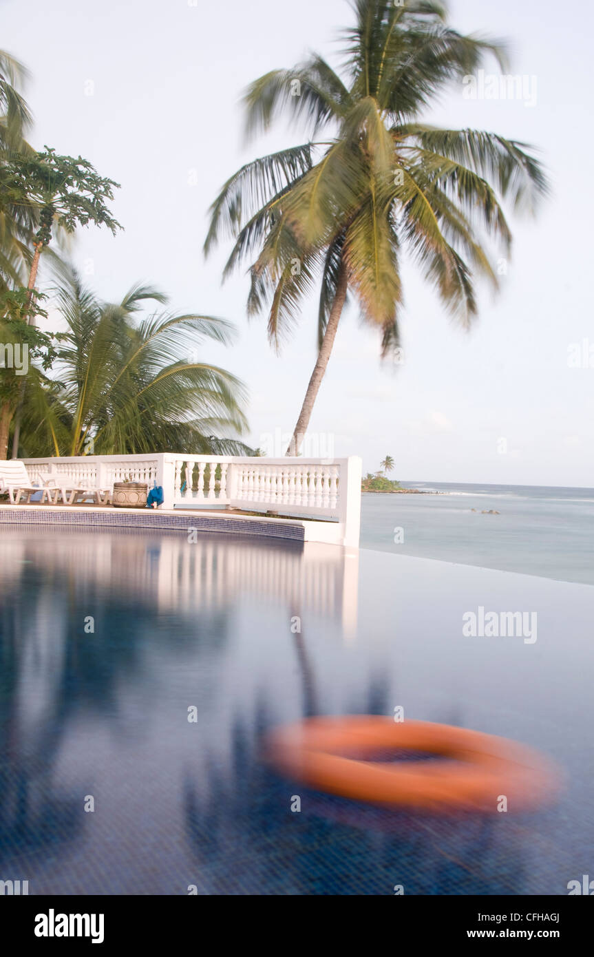 Piscina infinity salvavidas palmera de coco anochecer Corn Island Nicaragua  Fotografía de stock - Alamy