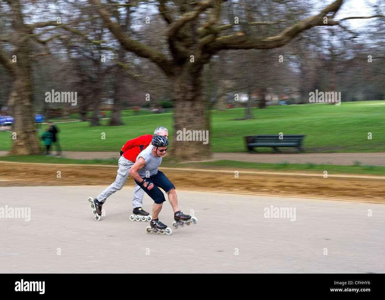 Dos hombres patinar a gran velocidad a través de Hyde Park en Londres Foto de stock
