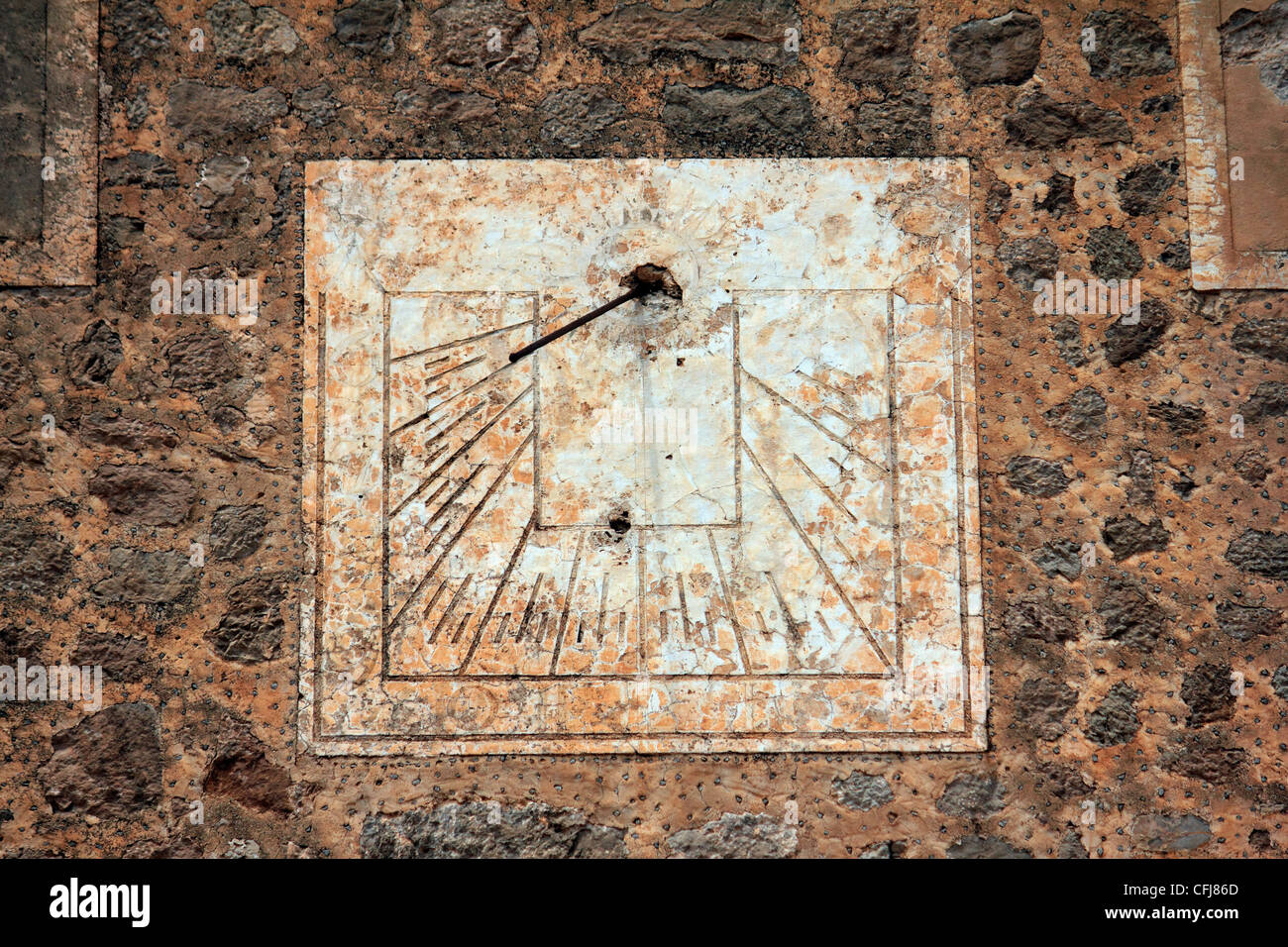 Antiguo reloj de sol en una vieja pared de adoquines Foto de stock