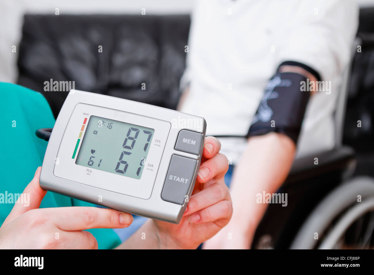 Chequeo de la presión arterial para adultos jóvenes en silla de ruedas. Foto de stock