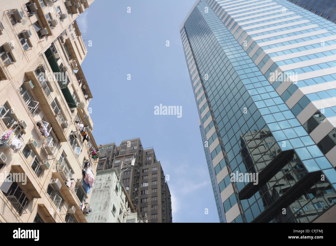 En contraste con la ciudad: un antiguo edificio residencial y una moderna torre de oficinas en Hong Kong Foto de stock
