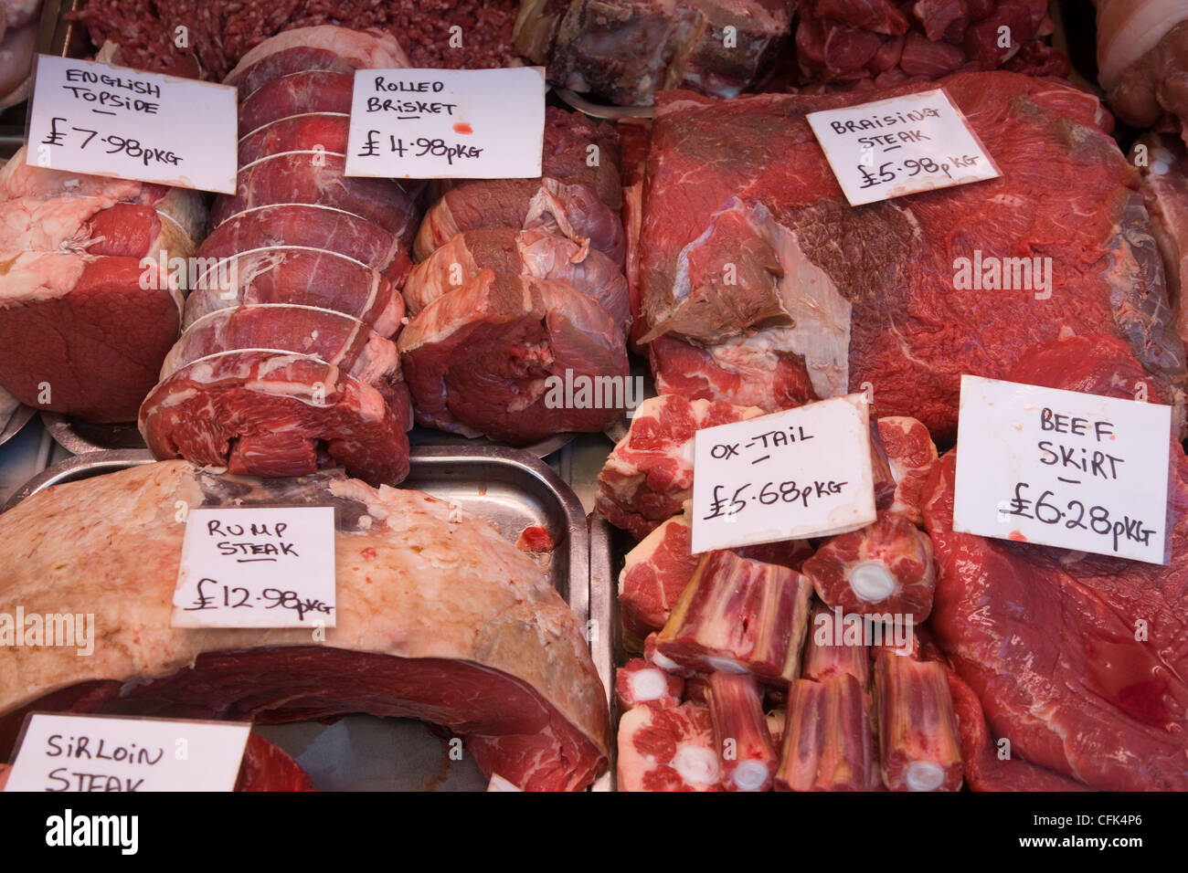 Carnes rojas: ternera, cerdo, cordero, rabo de toro, articulaciones y chuletas en la pantalla en una carnicería de la ventana Foto de stock
