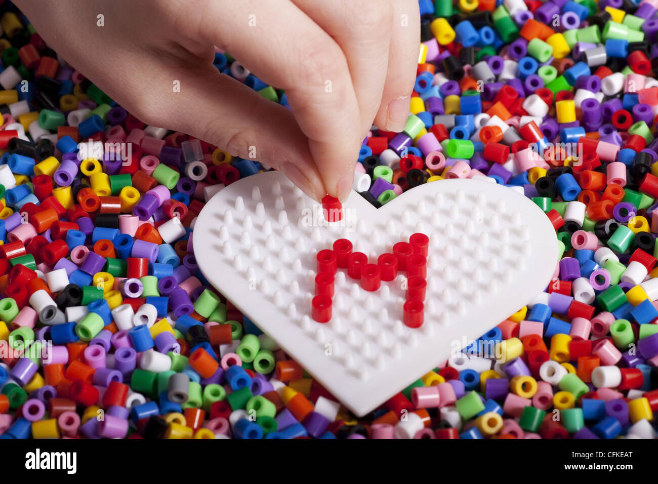 Multicolores de plástico Hama beads con corazón plantilla para artesanías  Fotografía de stock - Alamy