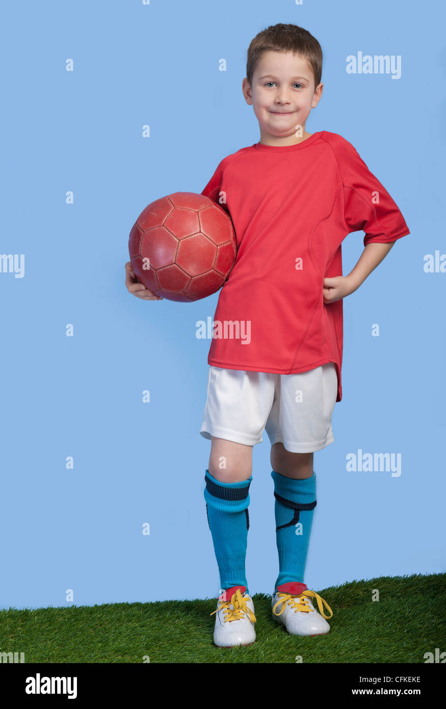 Un muchacho joven con traje con balón de fútbol contra un fondo azul  Fotografía de stock - Alamy