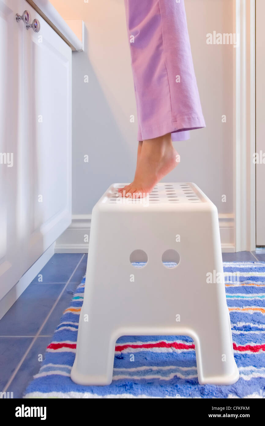 Chica de pie sobre reposapiés en el baño Fotografía de stock - Alamy