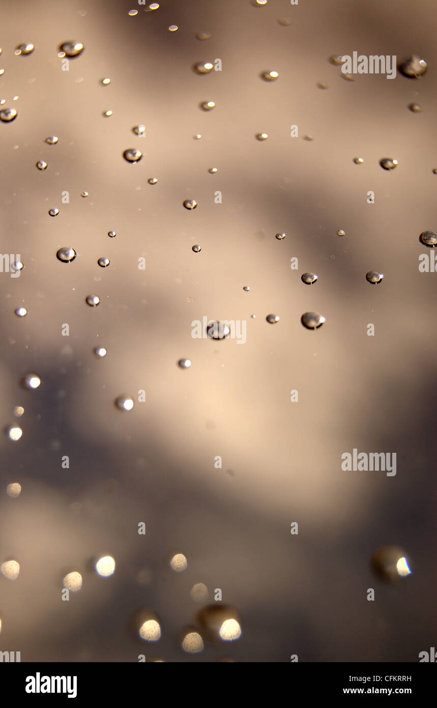 Las gotas de agua hacen un salvapantallas-like patrón en una ventana de cristal Foto de stock