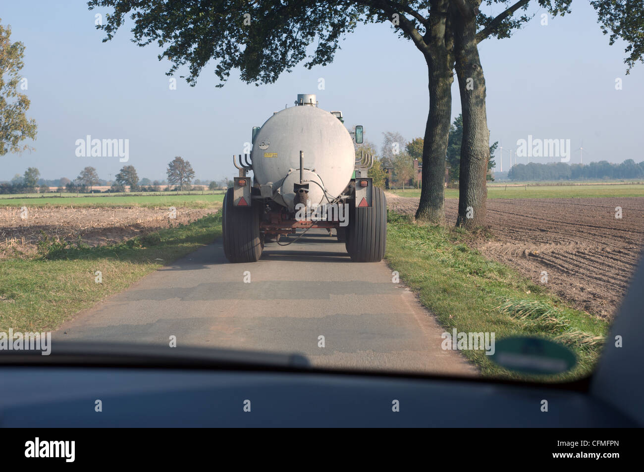 Movimiento lento del vehículo agrícola en un estrecho camino rural Foto de stock