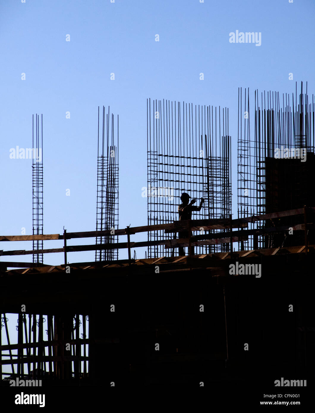 Silueta de un trabajador de la construcción en un sitio de construcción Foto de stock