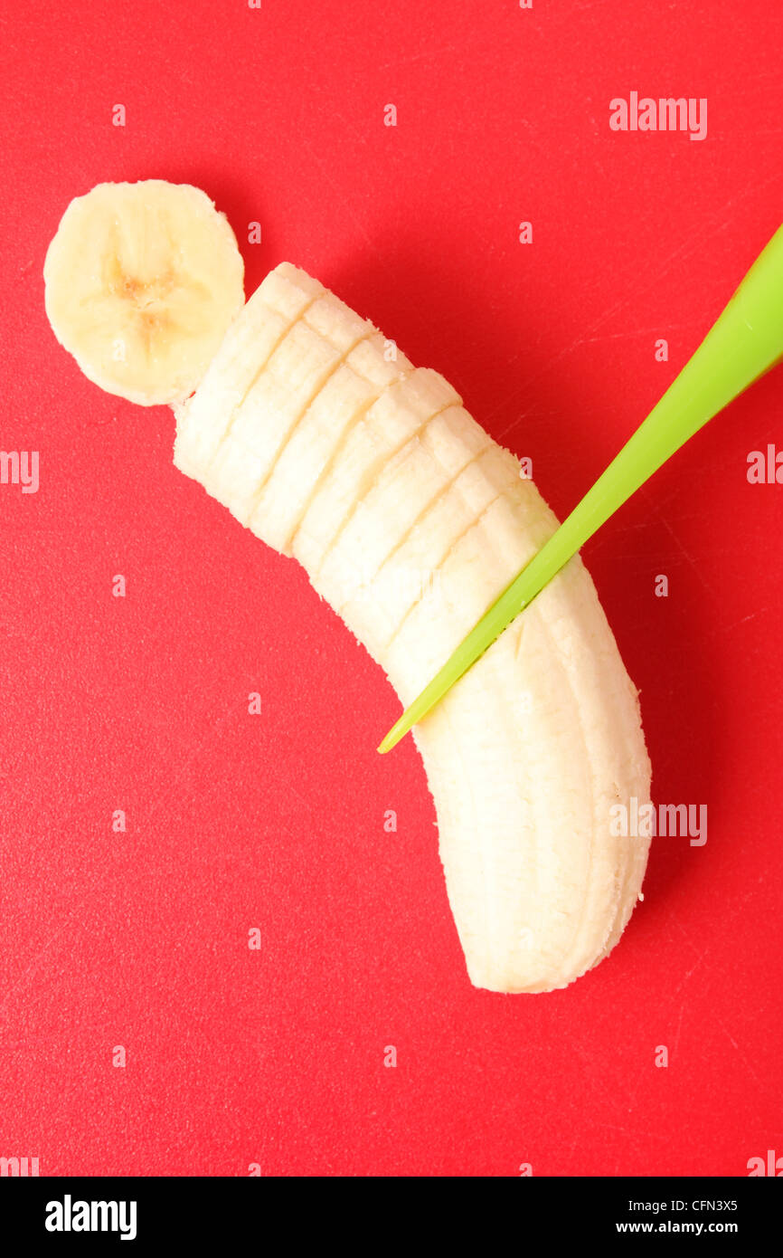 Plátano en rodajas sobre una tabla para cortar Foto de stock