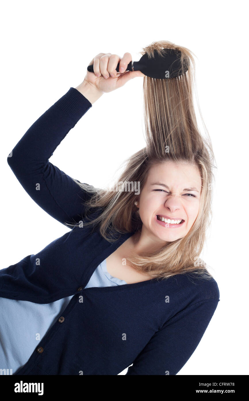 Mujer joven doloroso peluquería con cepillo, aislado sobre fondo blanco. Foto de stock