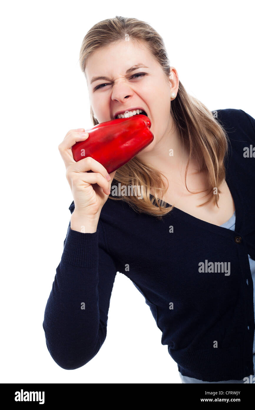 Mujer hambrientos de comer fresco pimentón rojo, aislado sobre fondo blanco. Foto de stock