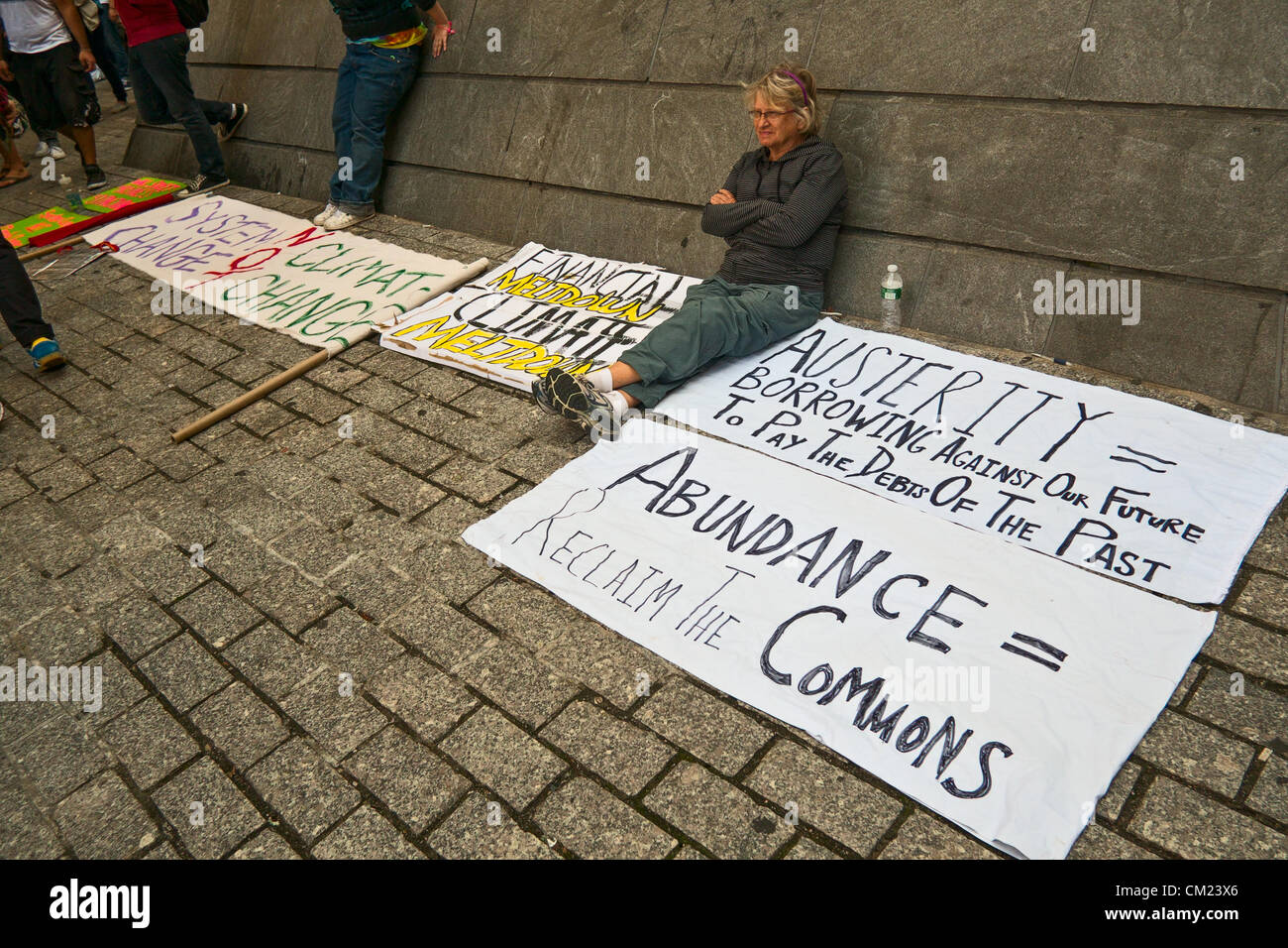 Nueva York, NY, 17 de septiembre de 2012. En el primer aniversario de las protestas Occupy Wall Street, mujer sentada por firmar criticando la austeridad movimiento Foto de stock