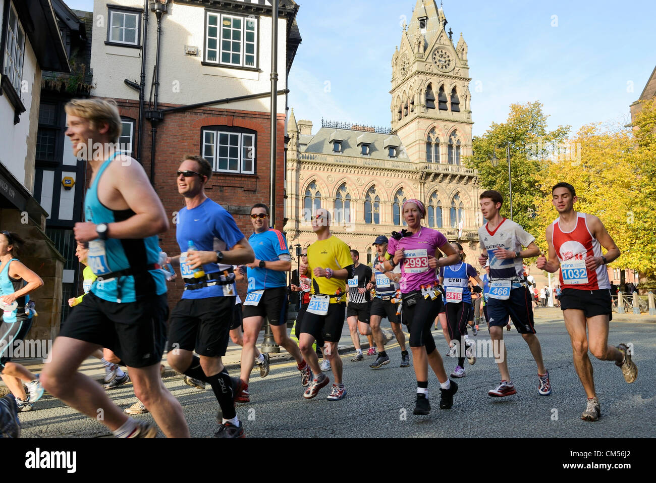 El 7 de octubre de 2012, Chester, Reino Unido. Poco después del inicio de la MBNA Chester, corredores de maratón pasan por delante del Ayuntamiento y a lo largo de St Werburgh Street. Foto de stock