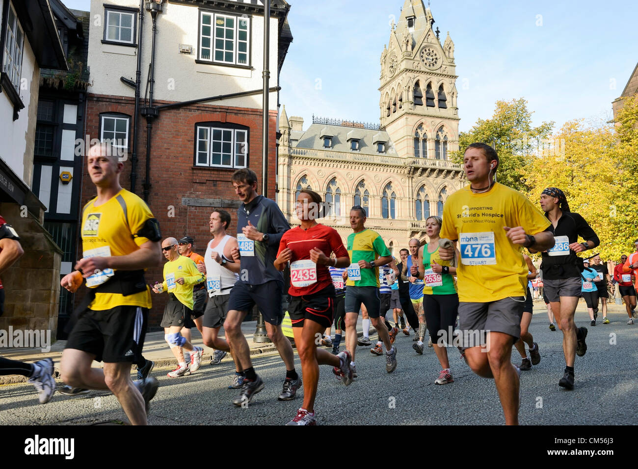 El 7 de octubre de 2012, Chester, Reino Unido. Poco después del inicio de la MBNA Chester, corredores de maratón pasan por delante del Ayuntamiento y a lo largo de St Werburgh Street. Foto de stock