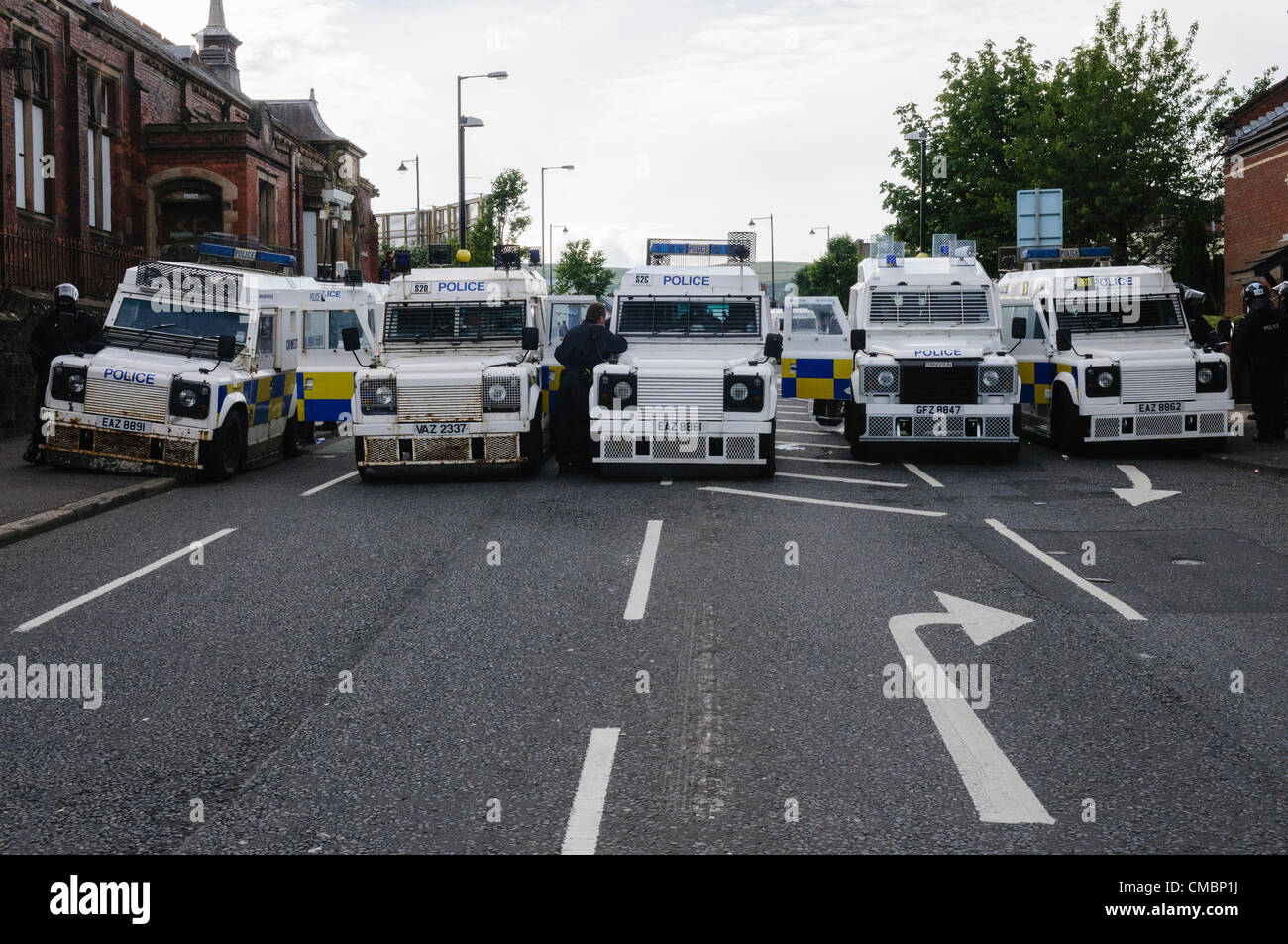 Belfast, 12/07/2012 - PSNI landrovers blindados cerrar carreteras para impedir que los republicanos y los unionistas entrechocar en Ardoyne 12 de julio desfile de la Orden de Orange Foto de stock