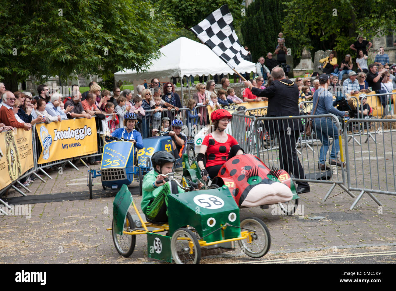 Los participantes toman parte en el British Grand Prix de 2012 coches de pedales. "Atrápame si puedes" evento se realizó en el cierre de carreteras en la ciudad. Foto de stock