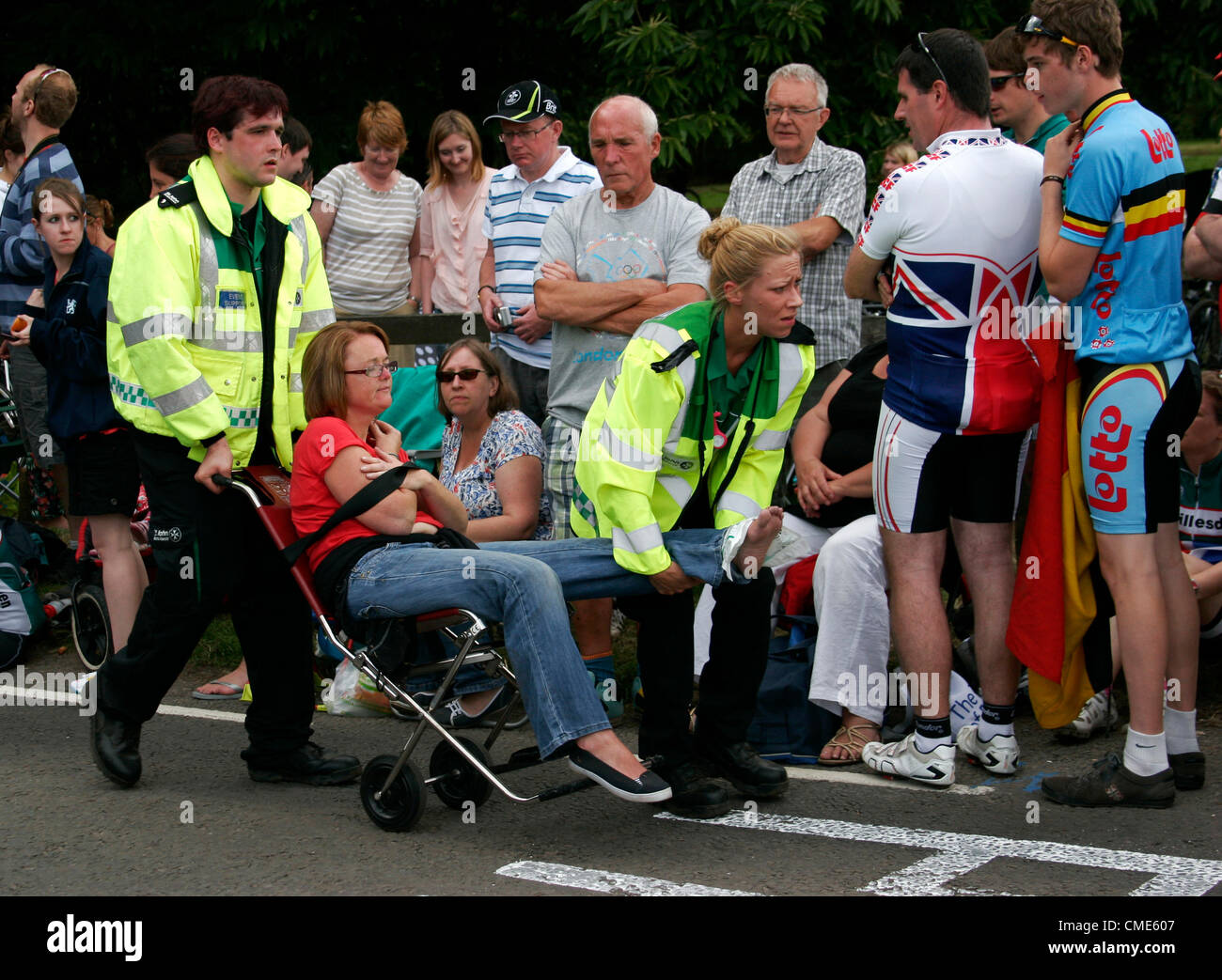 Un espectador ha tenido su pie aplastado por un vehículo mientras se ve Team GB ciclistas que toman parte en la carrera olímpica en Box Hill en Surrey que asistieron a una gran multitud que apoyaban ellos el 28 de julio de 2012 destinada a ganar la medalla de oro. Fue trasladada a recibir tratamiento por St Johns ambulancia. Foto de stock