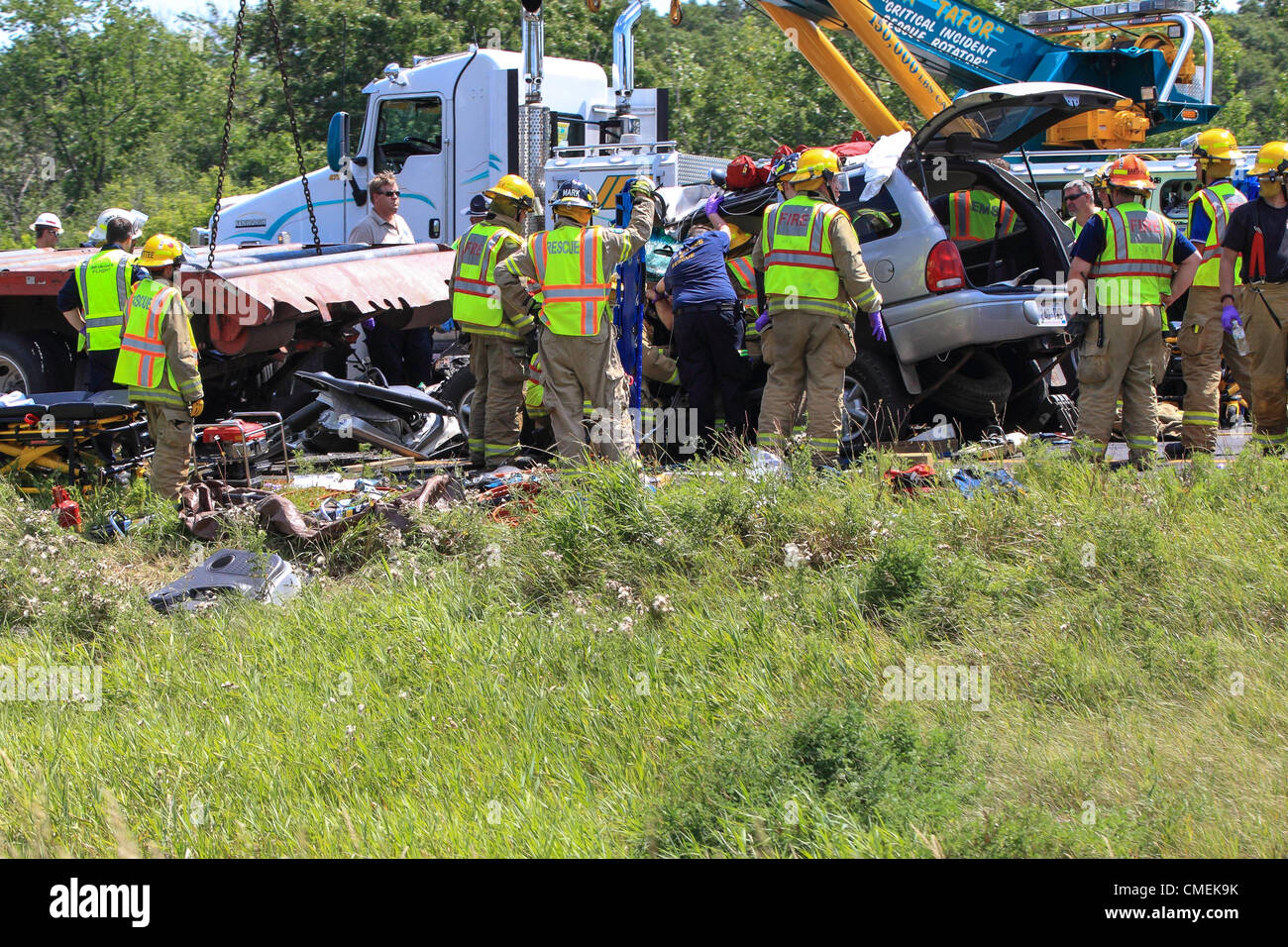 Lunes, 30 de julio, 2012 -- Los trabajadores de emergencia intenta liberar al conductor de un vehículo utilitario deportivo que se estrelló en la parte trasera de un semirremolque plataforma plana en la I-94 cerca de Mile Marker 6 en Hudson, Wisconsin, Estados Unidos. Al menos una persona murió en el accidente. Foto de stock