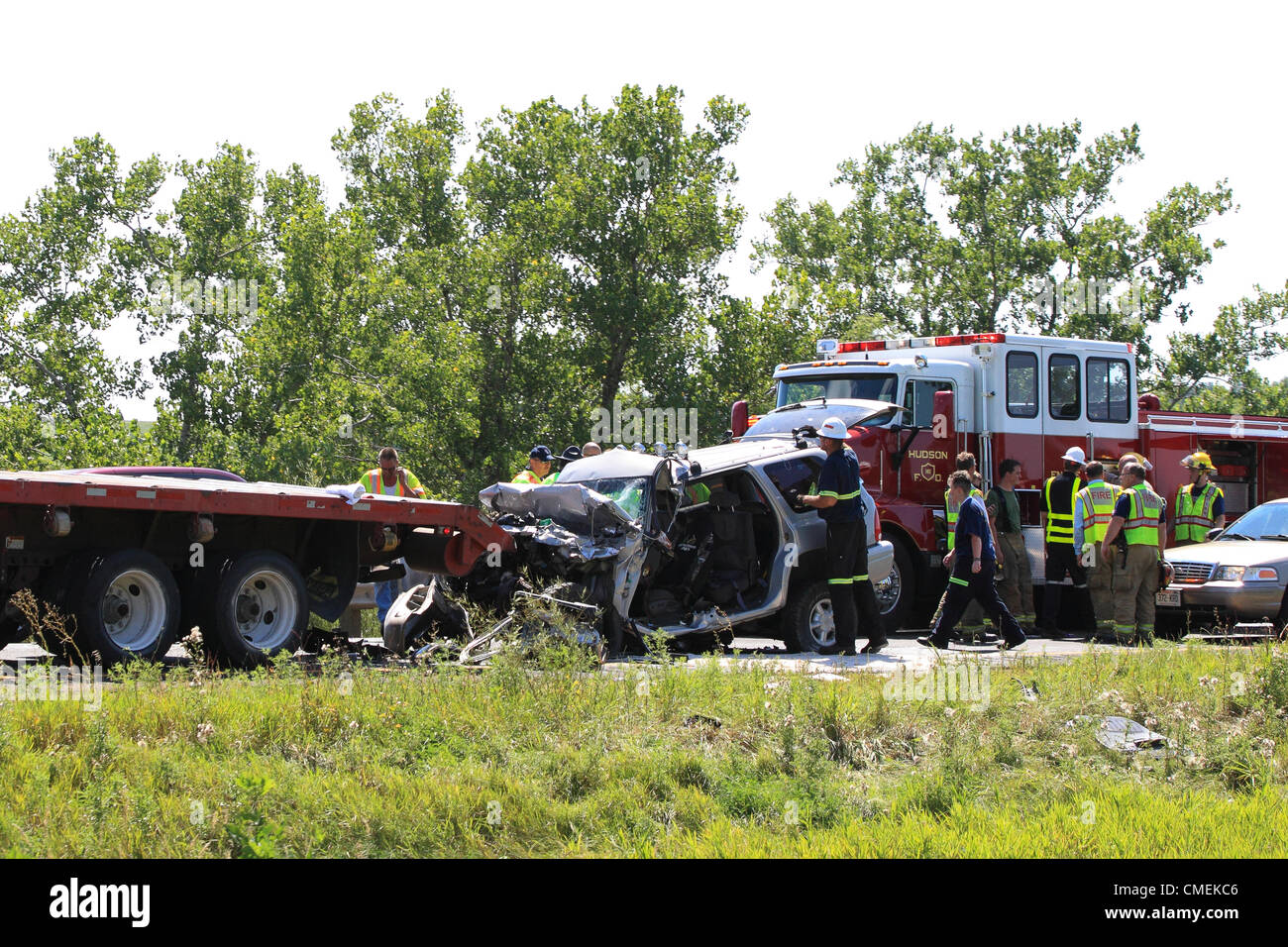 Lunes, 30 de julio, 2012 -- Los trabajadores de emergencia claro de la escena de un accidente fatal cerca de Hudson, Wisconsin, Estados Unidos. El accidente, que ocurrió cuando un vehículo utilitario deportivo se estrelló en la parte trasera de un semirremolque plataforma plana en la I-94 cerca de Mile Marker 6, causó al menos un muerto. Foto de stock