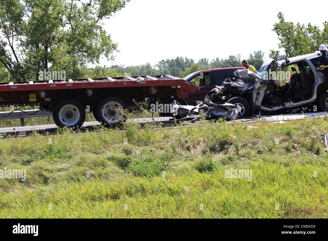 Lunes, 30 de julio, 2012 -- Los trabajadores de emergencia claro de la escena de un accidente fatal cerca de Hudson, Wisconsin, Estados Unidos. El accidente, que ocurrió cuando un vehículo utilitario deportivo se estrelló en la parte trasera de un semirremolque plataforma plana en la I-94 cerca de Mile Marker 6, causó al menos un muerto. Foto de stock