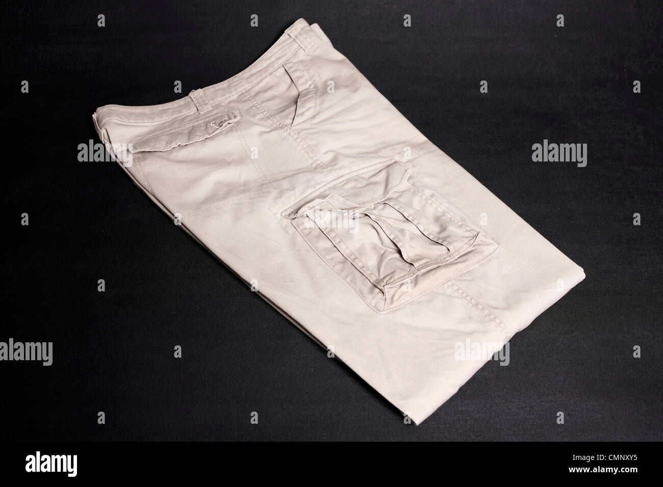 Un par de pantalones de algodón carga sobre un fondo negro Foto de stock