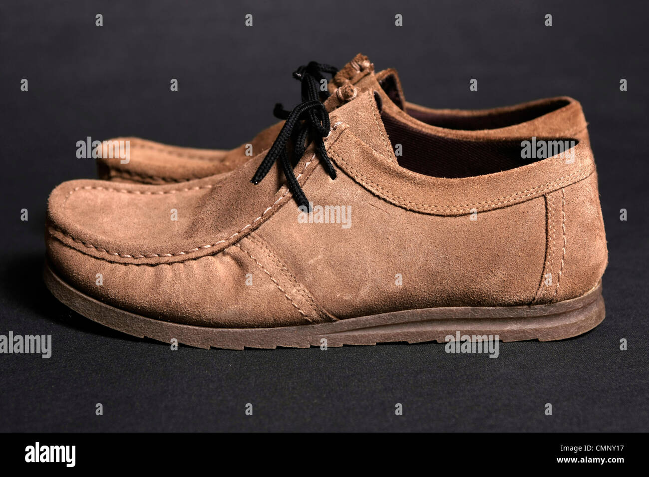Hombre zapatos de gamuza marrón sobre un fondo negro Foto de stock