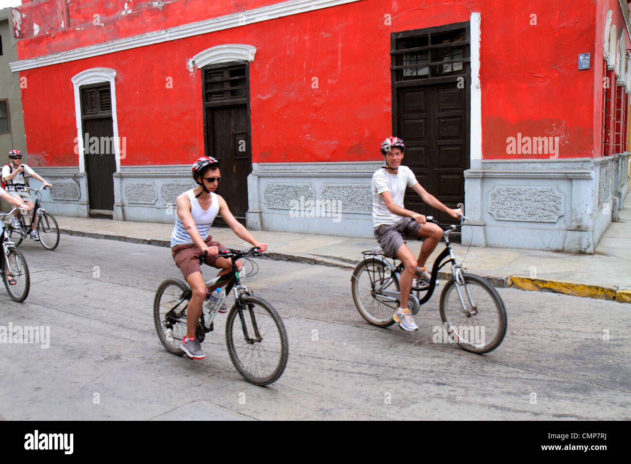 Lima Perú,Distrito Barranco,barrio,Calle Melgar,escena de calle,edificio,pared roja,bicicleta,ciclismo,montar,bicicleta,jinete,montar,pedalear,hombre mal Foto de stock