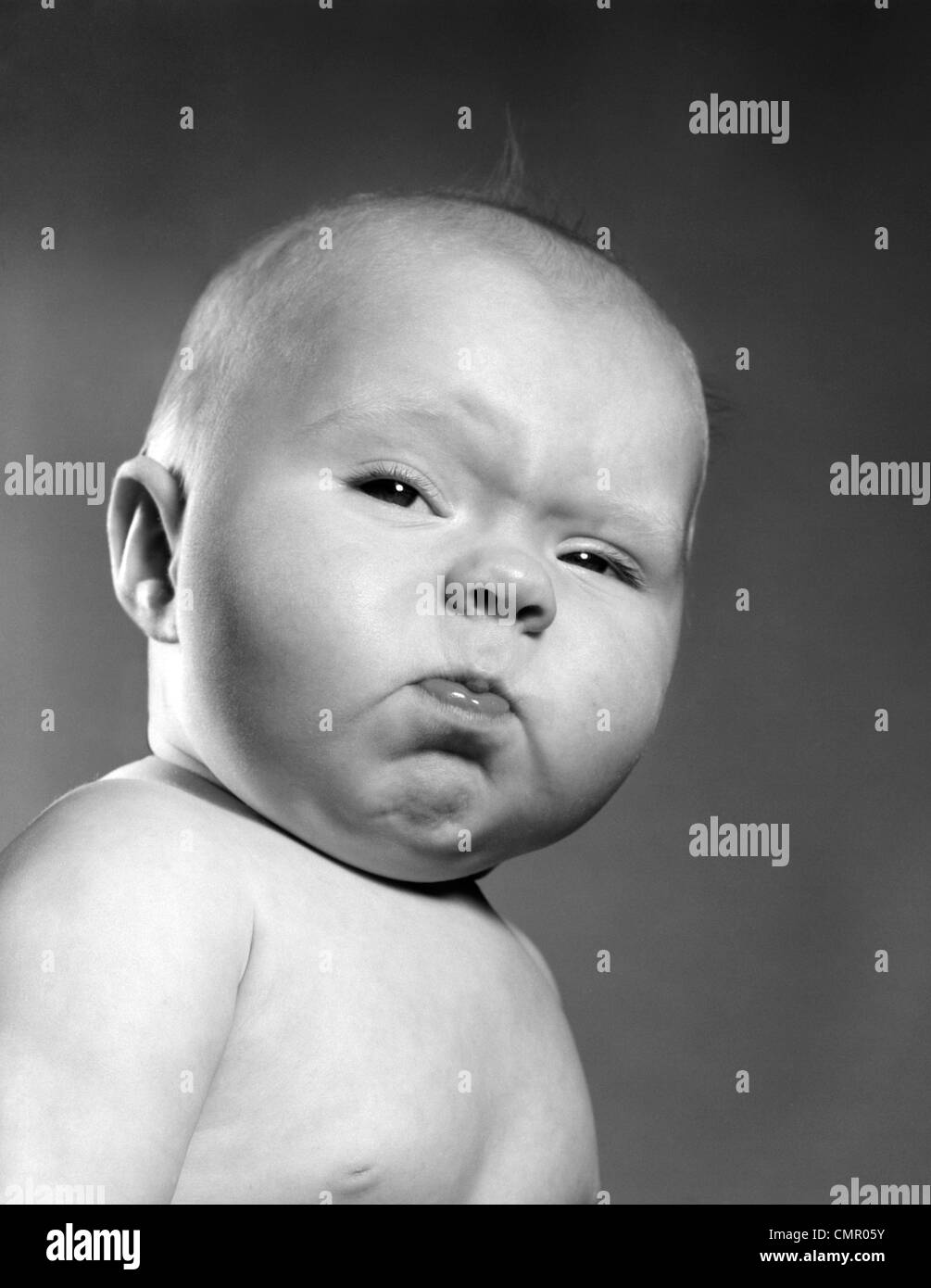 1950 disparo a la cabeza del bebé con divertidos arrugadas boca expresión facial Foto de stock