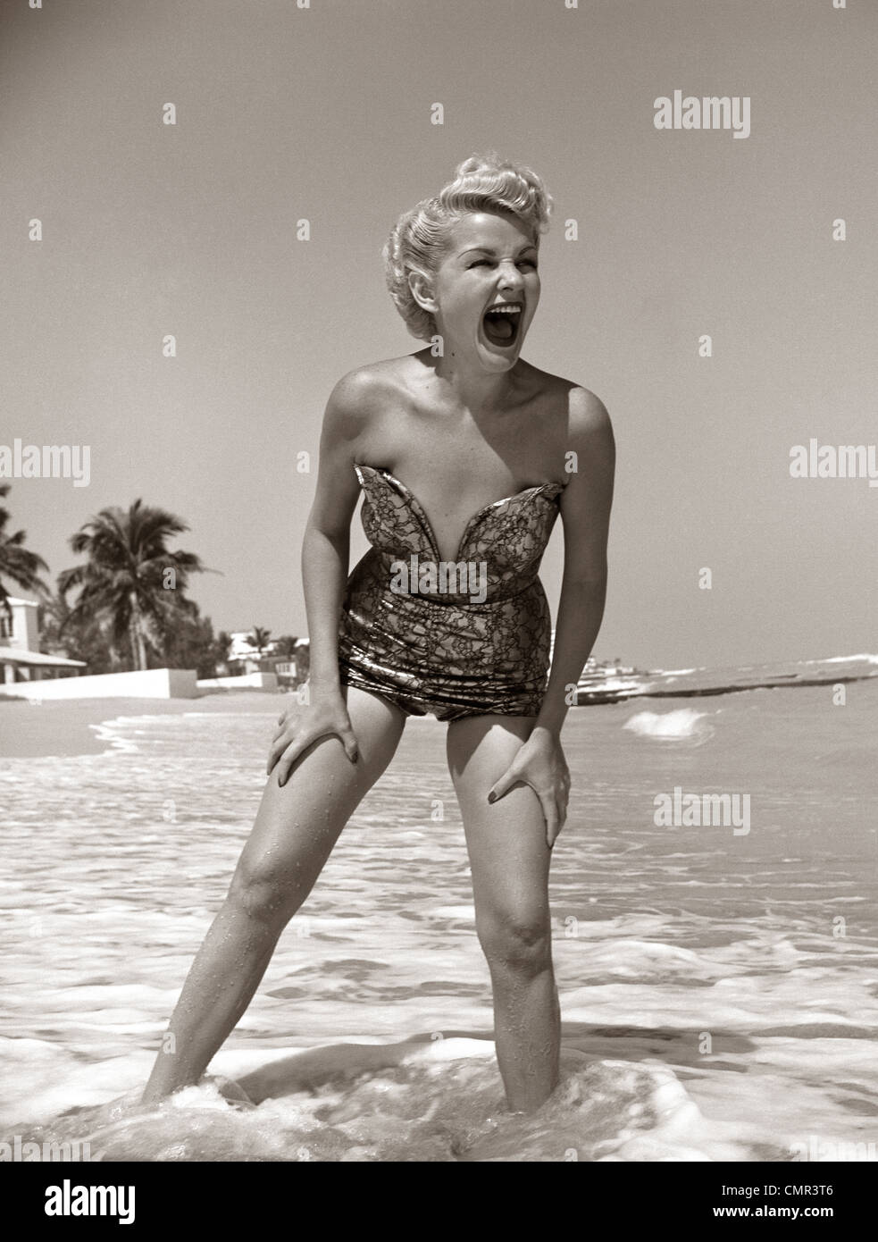 1950 RIENDO MUJER EN STRAPLESS CON CORTE BAJO Traje de baño Ropa de baño VADEANDO LOS TOBILLOS EN SURF de stock - Alamy