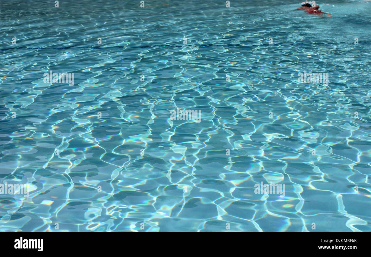 Nadador solitario en una enorme piscina de color azul Foto de stock